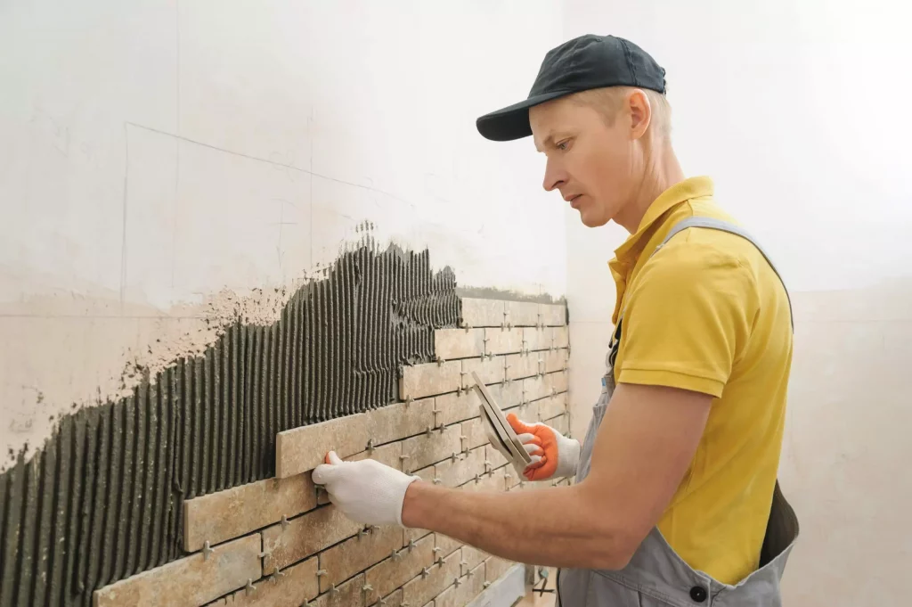 worker putting tiles form brick wall scaled 1